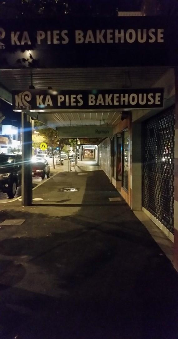 The shopping strip before under-awning lighting was installed